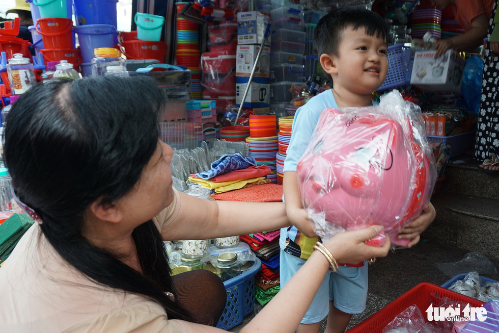 A boy holds a large-size piggy bank at a shop in Ho Chi Minh City, Vietnam. Photo: Tuoi Tre