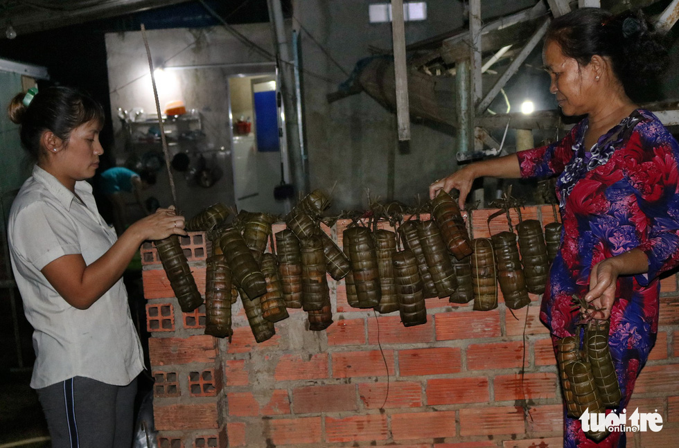 Cooked ‘banh tet’ are hung outside to dry and retain their cylindrical shape. Photo: Tuoi Tre
