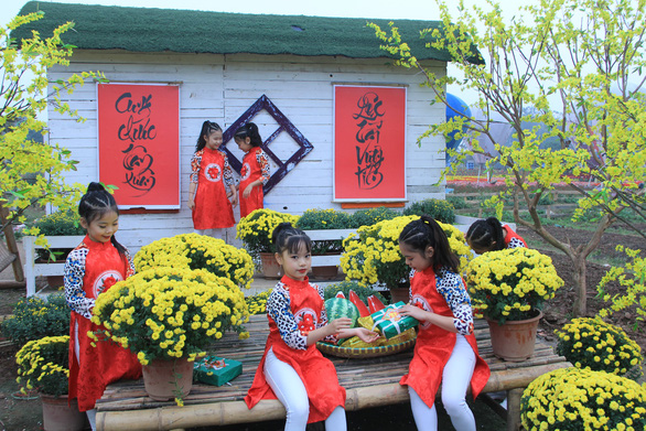 Little girls pose for a photo with chrysanthemums in Hanoi. Photo: Duong Lieu / Tuoi Tre