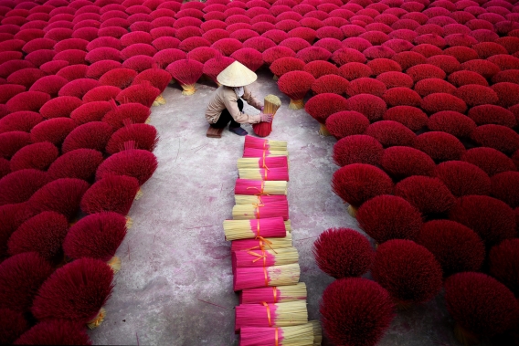 This picture taken on January 3, 2019 shows a Vietnamese woman collecting incense sticks in a courtyard in the village of Quang Phu Cau on the outskirts of Hanoi, Vietnam. Photo: AFP
