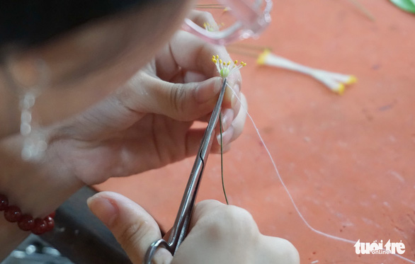 The pistils of a clay-made apricot blossom are carefully done by the artists. Photo: Tuyet Kieu / Tuoi Tre