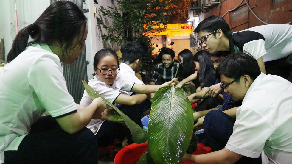 Children wash stachyphrynium placentarium leaves, used for wrapping banh chung, in Ho Chi Minh City, January 2019. Photo: Ngoc Phuong & Linh To / Tuoi Tre