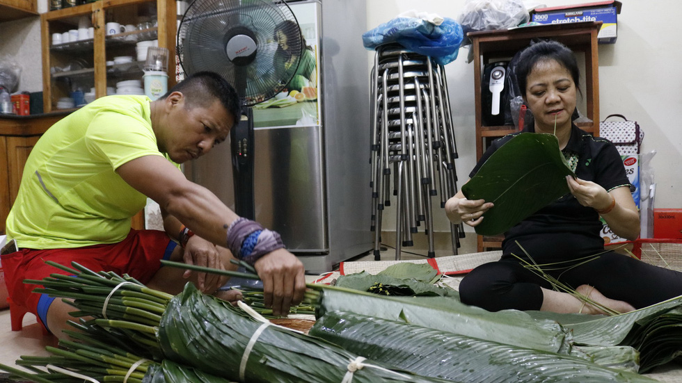 Bui Thi Hong Vinh and her husband prepare banh chung wrapping leaves at their home in Ho Chi Minh City, January 2019. Photo: Ngoc Phuong & Linh To / Tuoi Tre