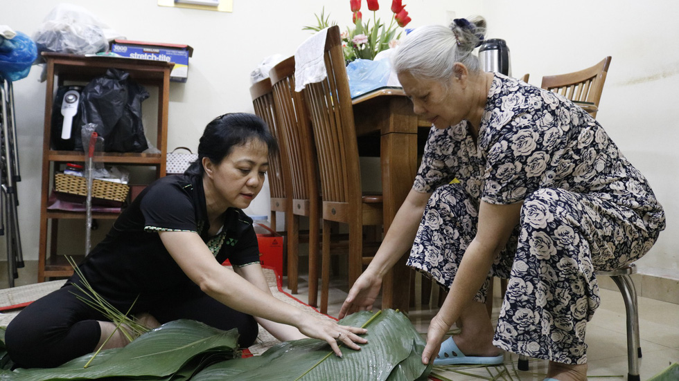 Bui Thi Hong Vinh (left) and her mother-in-law prepare wrapping leaves for banh chung at their home in Ho Chi Minh City, January 2019. Photo: Ngoc Phuong & Linh To / Tuoi Tre