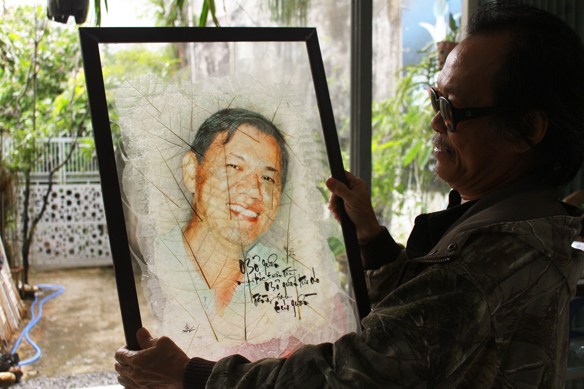 Le Nguyen Vy shows off one of his leaf artwork. Photo: Doan Nhan / Tuoi Tre
