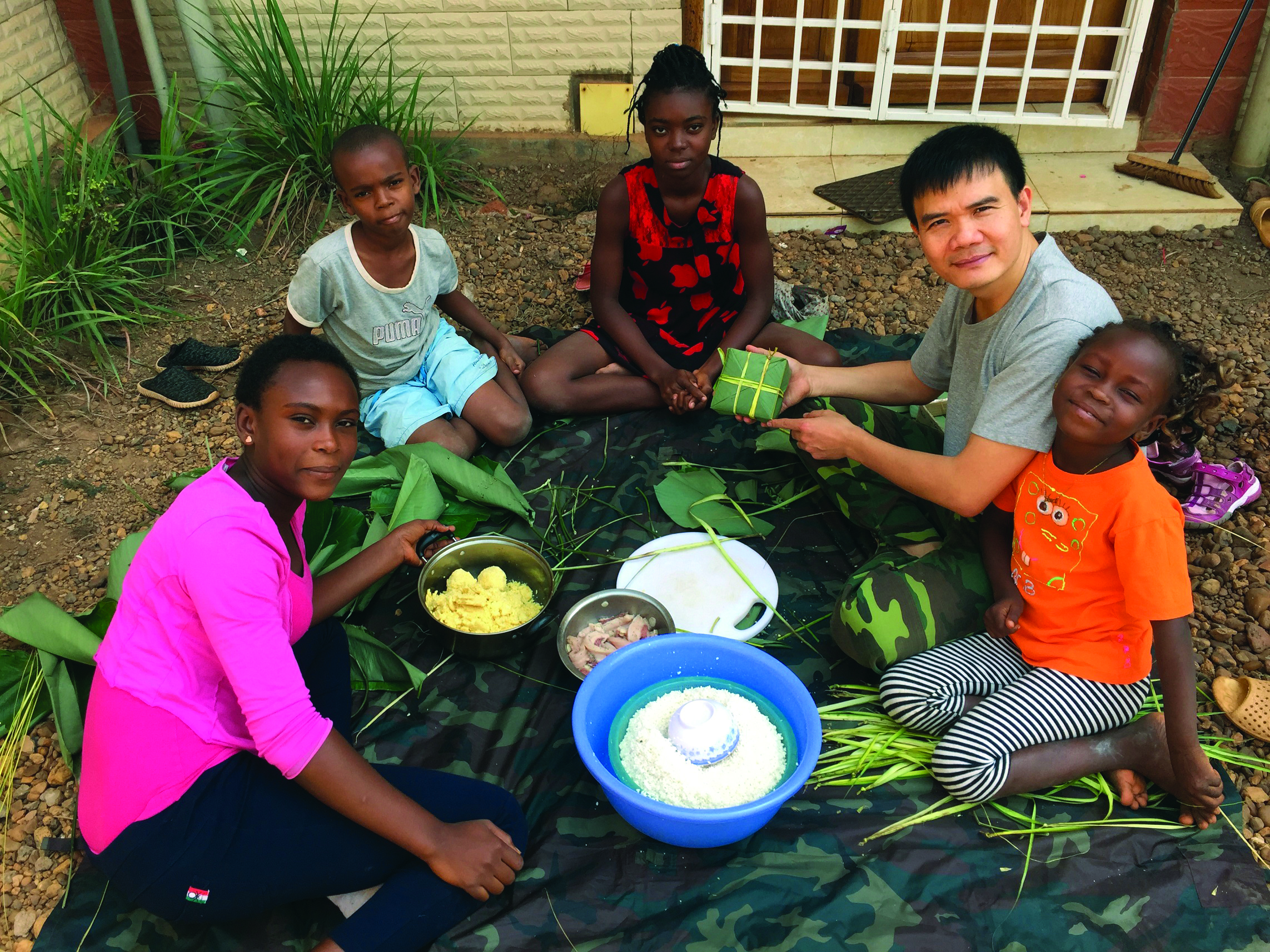 Lieutenant Colonel Le Ngoc Son make ‘banh chung’ with the help from Central African children. Photo: Dinh Duc Long