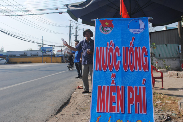 Nguyen Van Thanh offers bottled water and tissues to motorcyclists on a road in Dong Thap Province, southern Vietnam, January 30, 2019. Photo: Thanh Nhon / Tuoi Tre