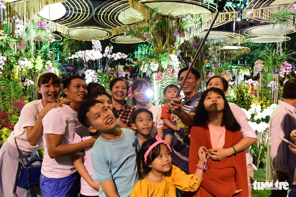 People pose for a group photo in the Nguyen Hue Street Flower in Ho Chi Minh City, February 2, 2019. Photo: Quang Dinh / Tuoi Tre