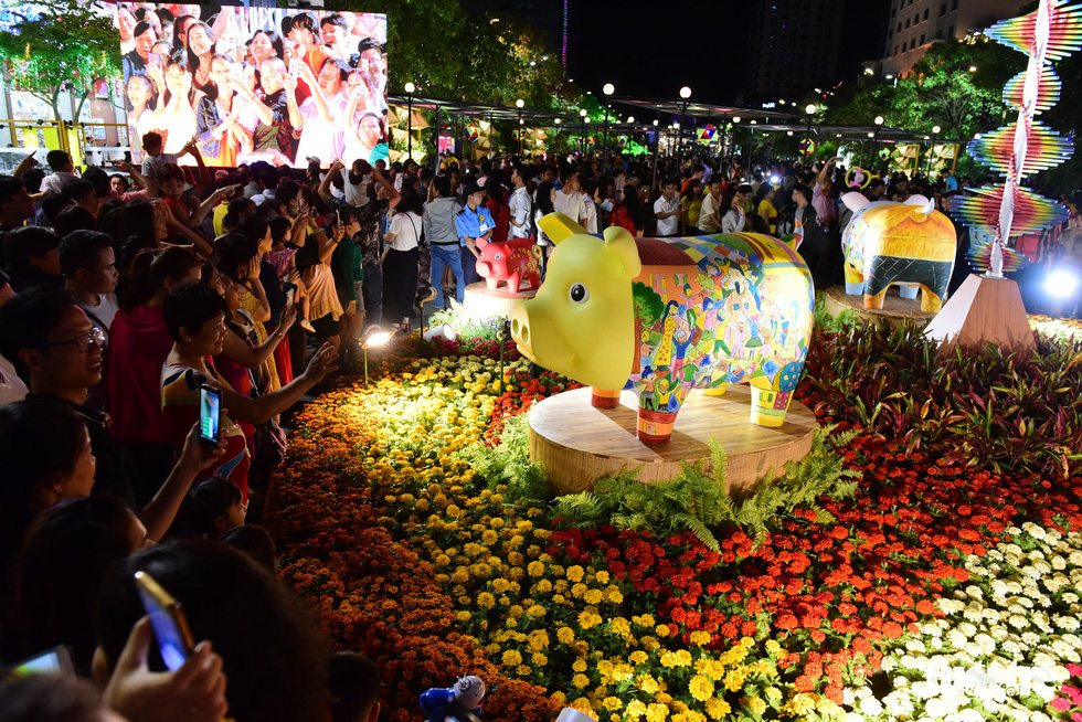 People take pictures of a large-sized swine statue in the Nguyen Hue Street Flower in Ho Chi Minh City, February 2, 2019. Photo: Quang Dinh / Tuoi Tre