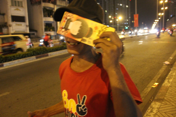 A man is happy as he has been given a lucky money envelope by a good-hearted passerby. Photo: My Lang / Tuoi Tre