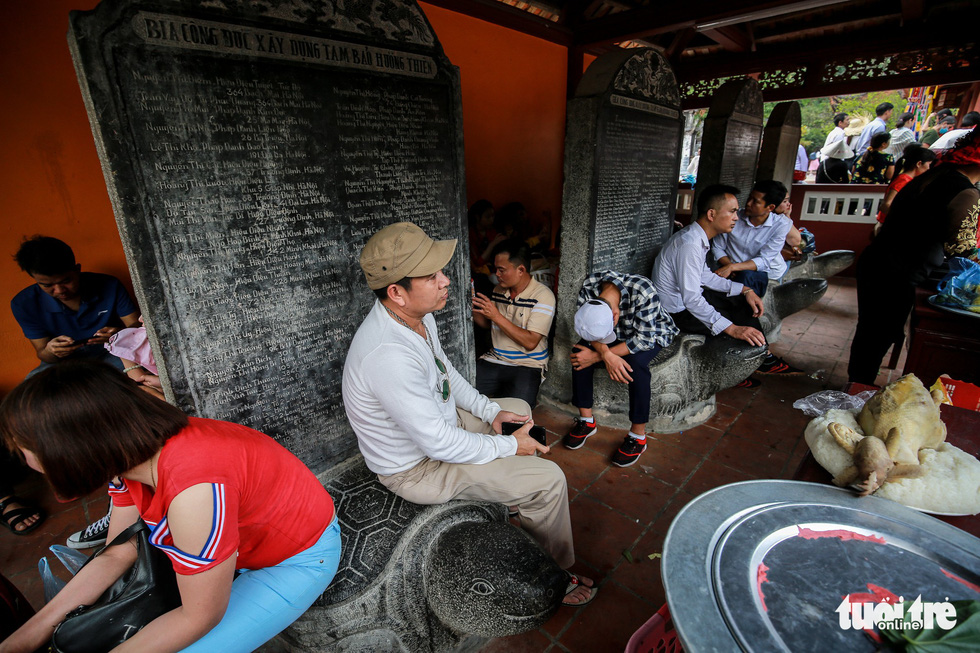 Visitors rest on stone turtles at the Huong Pagoda in rural Hanoi on February 10, 2019. Photo: Nam Tran / Tuoi Tre