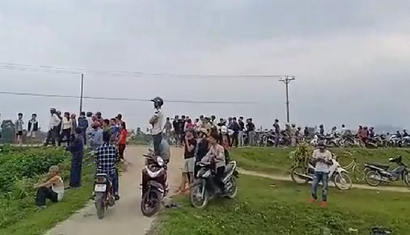 Local residents watch a standoff between police officers and a drug suspect in Ha Tinh Province in north-central Vietnam on February 15, 2019, as seen in a still photo taken from footage filmed by a local resident.