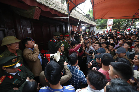 A local official convinces residents to calm down. Photo: Nam Tran / Tuoi Tre