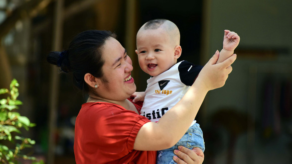 Huynh Kim Hue plays with her first child born through in vitro fertilization sponsored by a program that supports infertile couples in Vietnam. Photo: Duyen Phan / Tuoi Tre