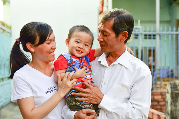 A couple plays with their child born through in vitro fertilization sponsored by a program that supports infertile couples in Vietnam. Photo: Huu Thuan / Tuoi Tre