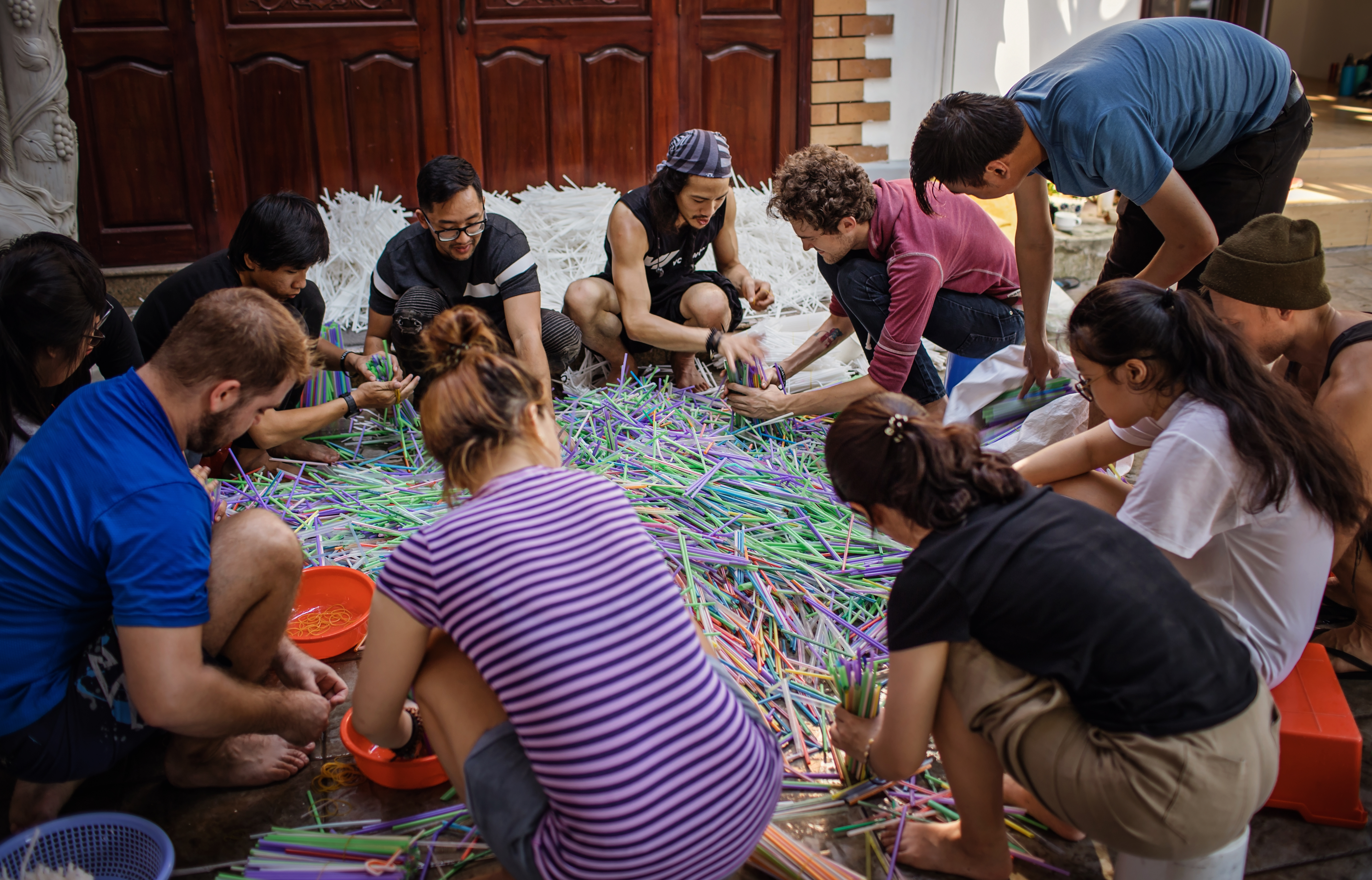 Volunteers join Von Wong to sort the straws before washing them for The Parting of The Sea. Photo: Anna Tenne