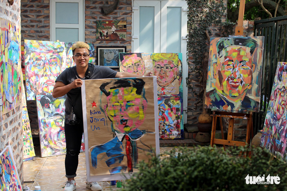 A local youth takes a photo with one of the paintings. Photo: Chi Tue / Tuoi Tre