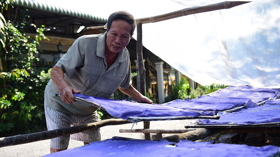 A man dries flour at his home-based workshop in the Sa Dec Flour Village in Dong Thap Province, southwestern Vietnam. The covering paper is to quicken the drying and give flour a beautiful hue, he says. Photo: C. Quoc, D. Phan & T. Nhon / Tuoi Tre