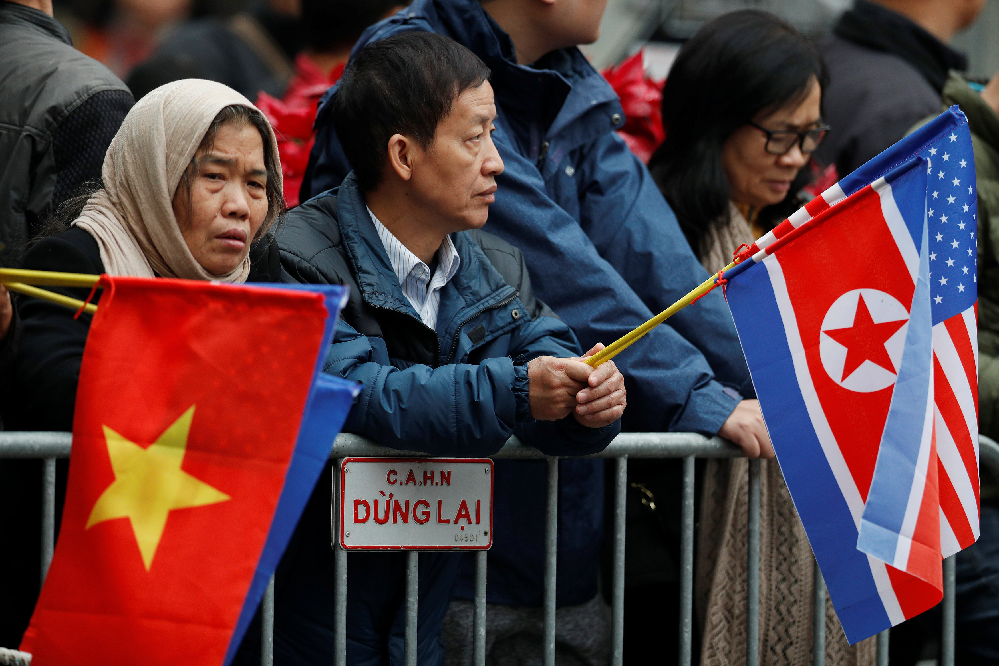 <em>People hold the national flags of Vietnam, North Korea, and the U.S. as they wait for the motorcade of North Korean leader Kim Jong Un outside the Melia hotel ahead of the North Korea-U.S. summit in Hanoi, Vietnam February 26, 2019. Photo: </em>Reuters