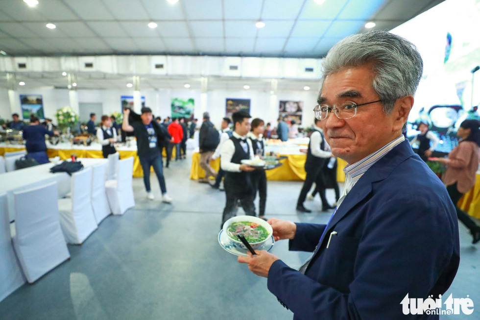 A Japanese reporter carries a bowl of ‘pho.’ Photo: Nguyen Khanh / Tuoi Tre
