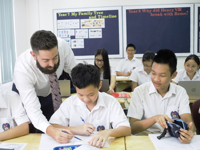 Mr Bradley Minchin (left) with his students in a history class.