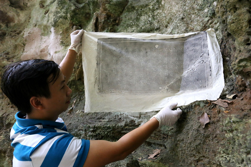 A researcher makes a copy of an engraving at the Ngu Hanh Son Mountains in Da Nang. Photo: Nguyen Van Thinh / Tuoi Tre