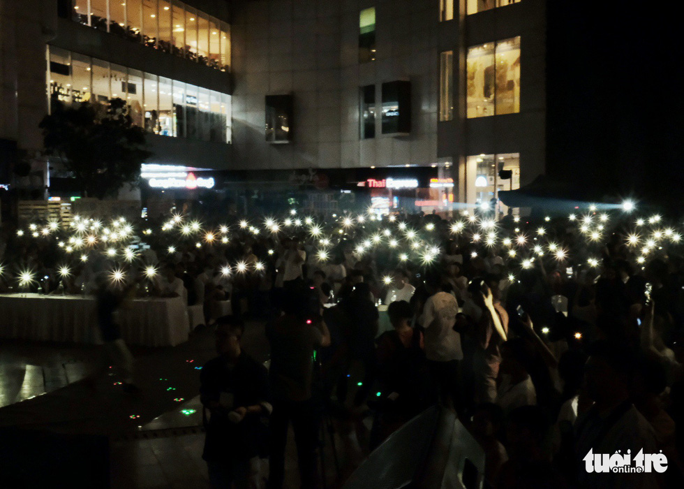 Participants turn on the flash lights of their mobile phones during the event. Photo: Mai Thuong / Tuoi Tre