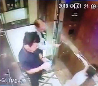 A security guard helps the girl pick her floor, while Linh is using his phone insdie the elevator. Photo: Facebook
