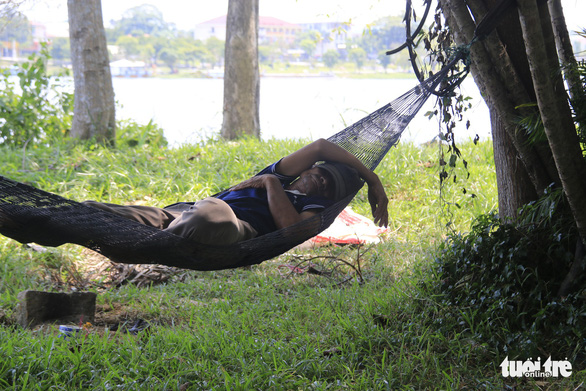 A resident takes a nap on a hammock at a park in Hue City. Photo: Nhat Linh / Tuoi Tre