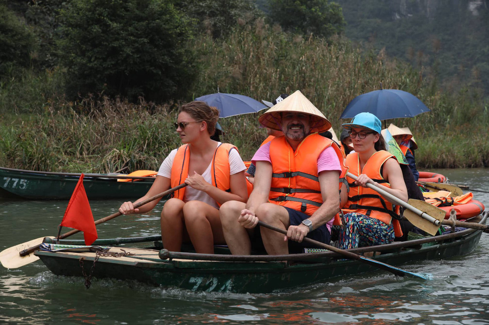 Foreign visitors enjoy the beauty of Trang An on a boat. Photo: Mai Thuong / Tuoi Tre