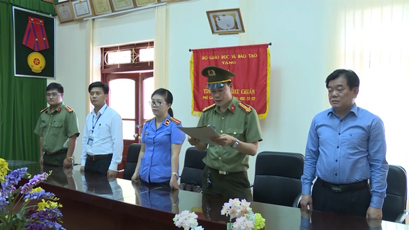 Police officers announce the arrest and prosecution of an education official in Son La Province in northern Vietnam in this still photo taken from a police video.