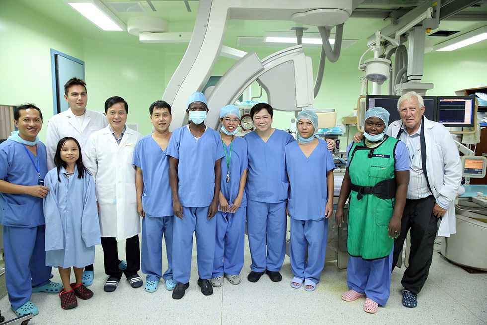 Doctor Do Quang Huan (fourth from left), director of Heart Hospital Ho Chi Minh City, is seen in a photo with his team, foreign doctors who came to learn from Vietnam’s procedures, and a cardiac patient. Photo: Mai Chi / Tuoi Tre