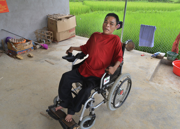 Hoang Than sits on his very first wheelchair after 50 years moving of crawling. Photo: Vu Tuan / Tuoi Tre