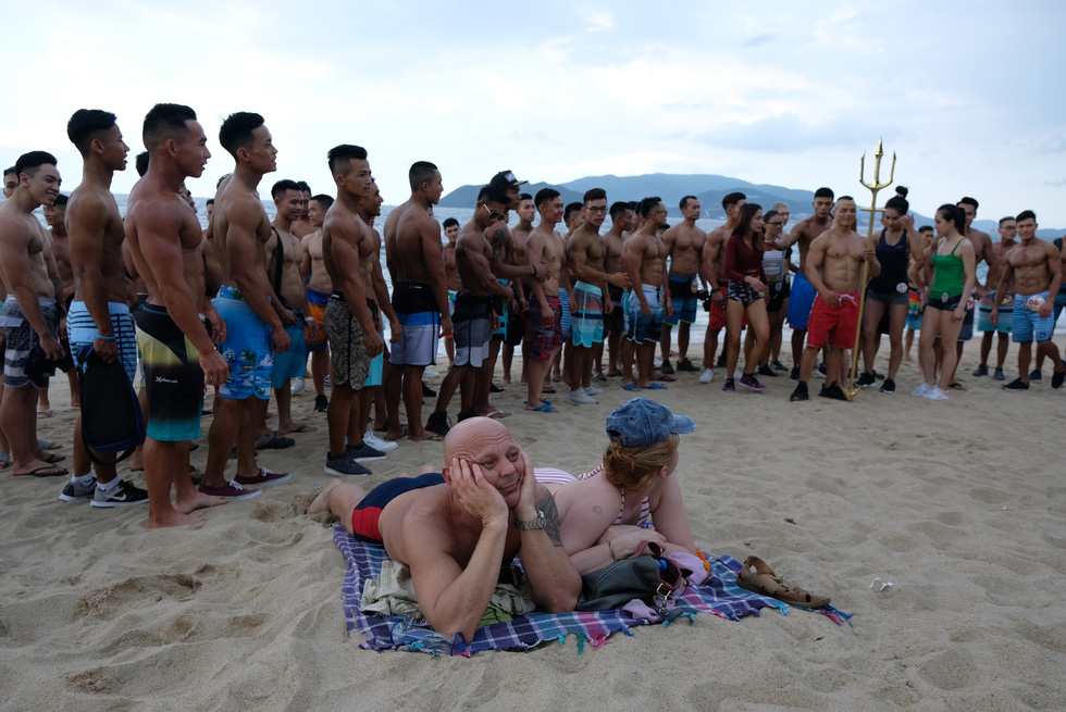 Visitors feast their eyes on the bodybuilders’ nice shapes. Photo: Dinh Cuong / Tuoi Tre