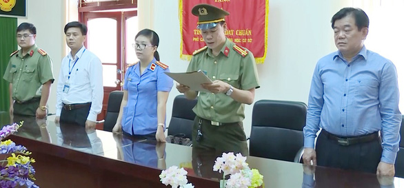 Hoang Tien Duc (R), director of the Department of Education and Training of Son La Province, witnesses the arrest of a provincial official on July 31, 2018 in this still photo taken from police footage.