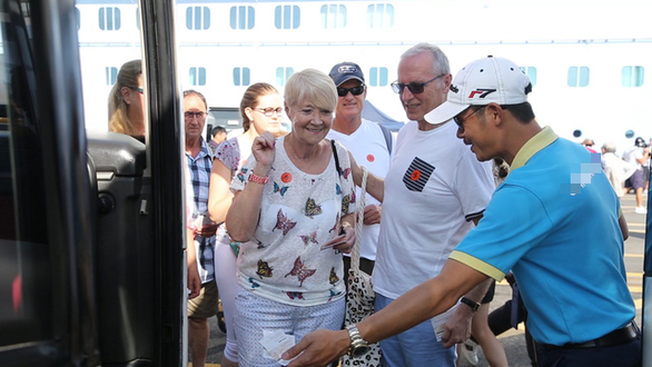 Cruise passengers are seen in this photo beside a tour guide in a uniform at Phu My Port in Ba Ria-Vung Tau Province, southern Vietnam. Photo: Tuoi Tre