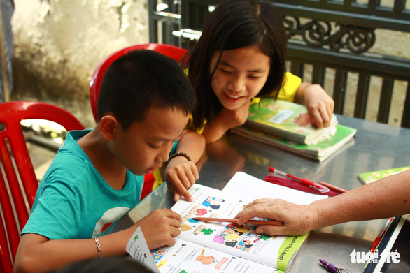 Tran Thi Huong (not seen) tutors children at her home in Da Nang, Vietnam. Photo: Tan Luc / Tuoi Tre