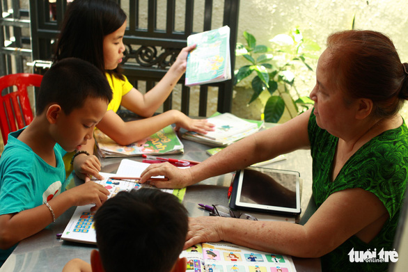 Tran Thi Huong tutors children at her home in Da Nang, Vietnam. Photo: Tan Luc / Tuoi Tre