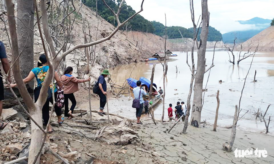 People walk in mud to be able to reach the boats at a dock in Ban Ve hydroelectric reservoir, Tuong Duong District, the north-central province of Nghe An. Photo: Lo Tu / Tuoi Tre