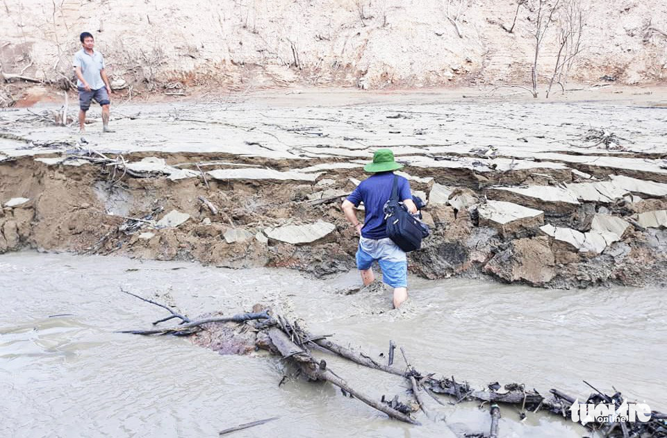 People walk in mud to be able to reach the boats at a dock in Ban Ve hydroelectric reservoir, Tuong Duong District, the north-central province of Nghe An. Photo: Lo Tu / Tuoi Tre