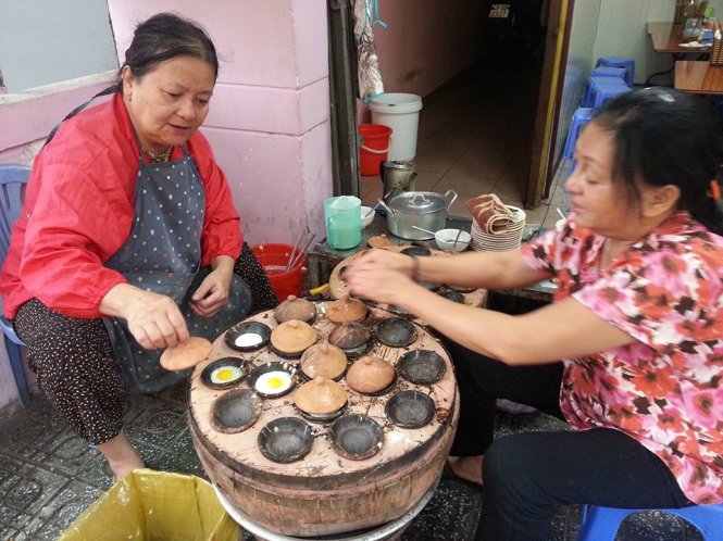 Two women cook banh can in Da Lat, Vietnam’s Central Highlands. Photo: Huyen Tran / Tuoi Tre