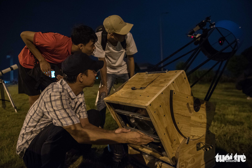 Participants line up to have a close look at the eclipse through the telescope. Photo: Hoang Thanh Tung / Tuoi Tre