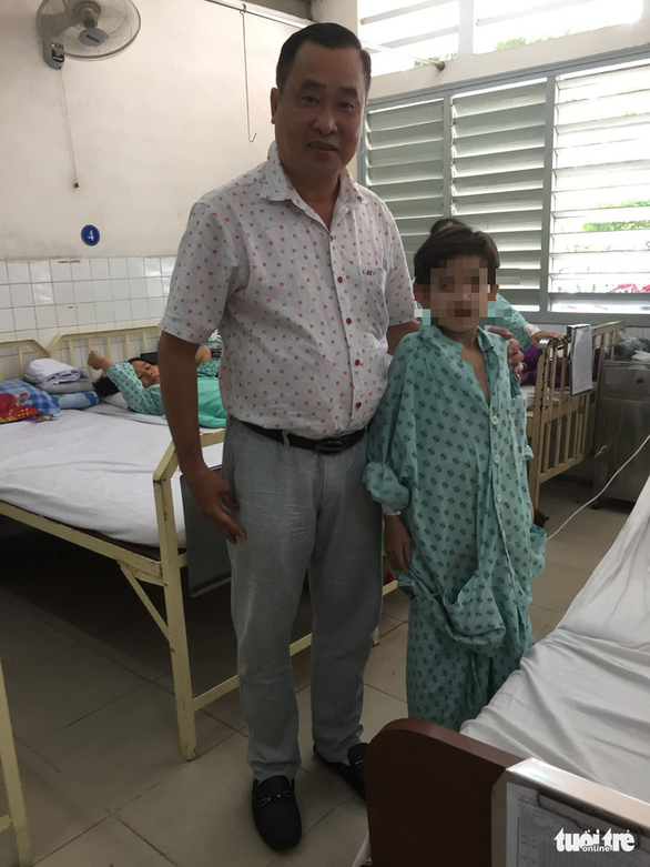 Dr. Nguyen Van Tien with the patient. Photo: Thuy Duong / Tuoi Tre