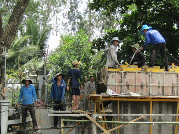 Members of the group build a bridge to elevate the transportation quality of people in a small commune in Vietnam’s Mekong Delta. Photo: T. T. Liem / Tuoi Tre