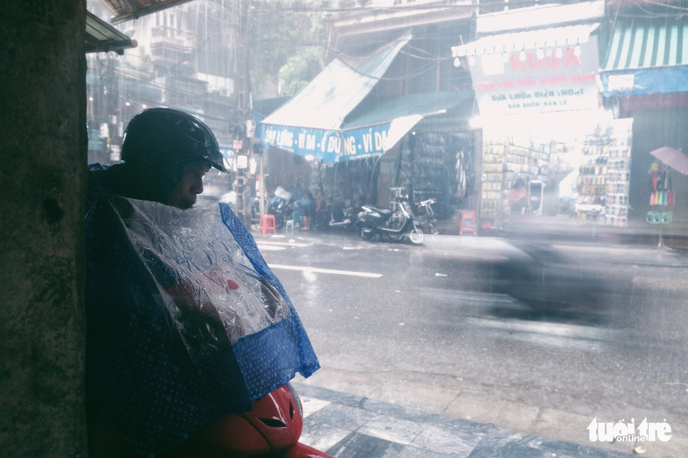 A motorbike taxi driver parks his vehicle on a corner of a street. Photo: Mai Thuong / Tuoi Tre