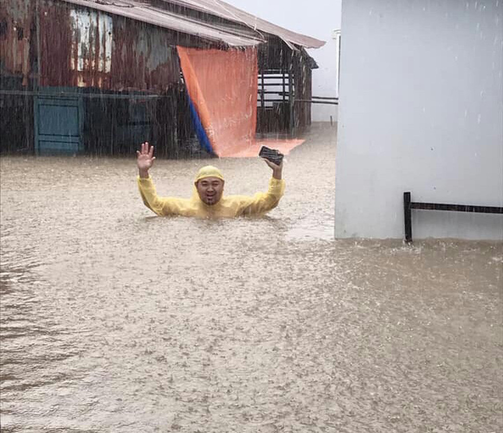 A man stands in the middle of chest-high rainwater in Duong Dong Town on Phu Quoc Island. Photo: Duong Ngan / Tuoi Tre
