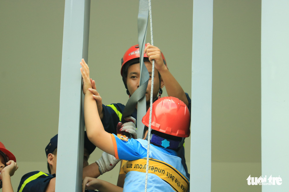 A child practices exit from a building by using rescue rope during a firefighting training. Photo: Le Van Quang / Tuoi Tre