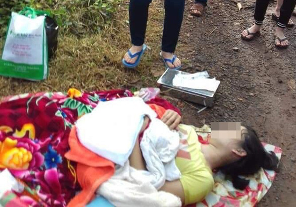 A woman clings to her dead newborn son as she lies on the side of a road in Binh Phuoc Province, Vietnam after being forced off a rental car on August 17, 2019. Photo: Tuoi Tre
