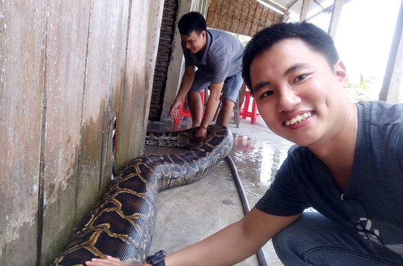 Pham Dung poses for a photo with a gigantic python in Vietnam’s Mekong Delta province of Tien Giang. Photo: Supplied