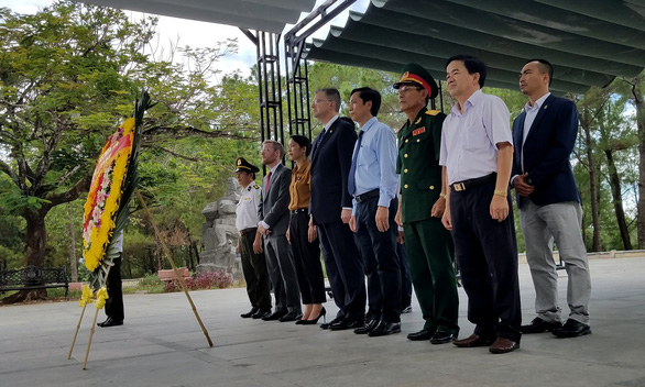 U.S. diplomats and Vietnamese officials stand in silence as they offer flowers to fallen Vietnamese soldiers at the Truong Son National Martyrs’ Cemetery in Quang Tri Province, Vietnam on August 27, 2019. Photo: Quoc Nam / Tuoi Tre